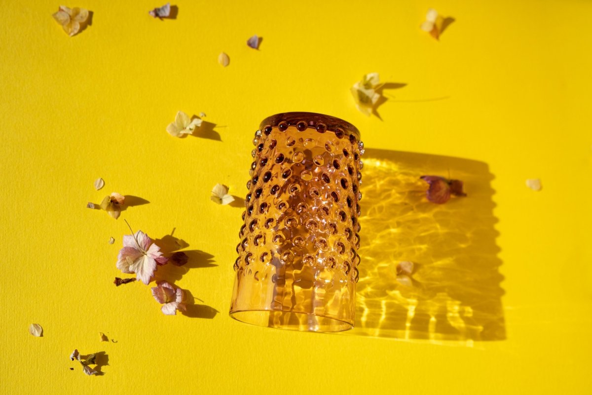 Underlay Violet Hobnail Tumblers on a yellow ground surrounded by flower petals