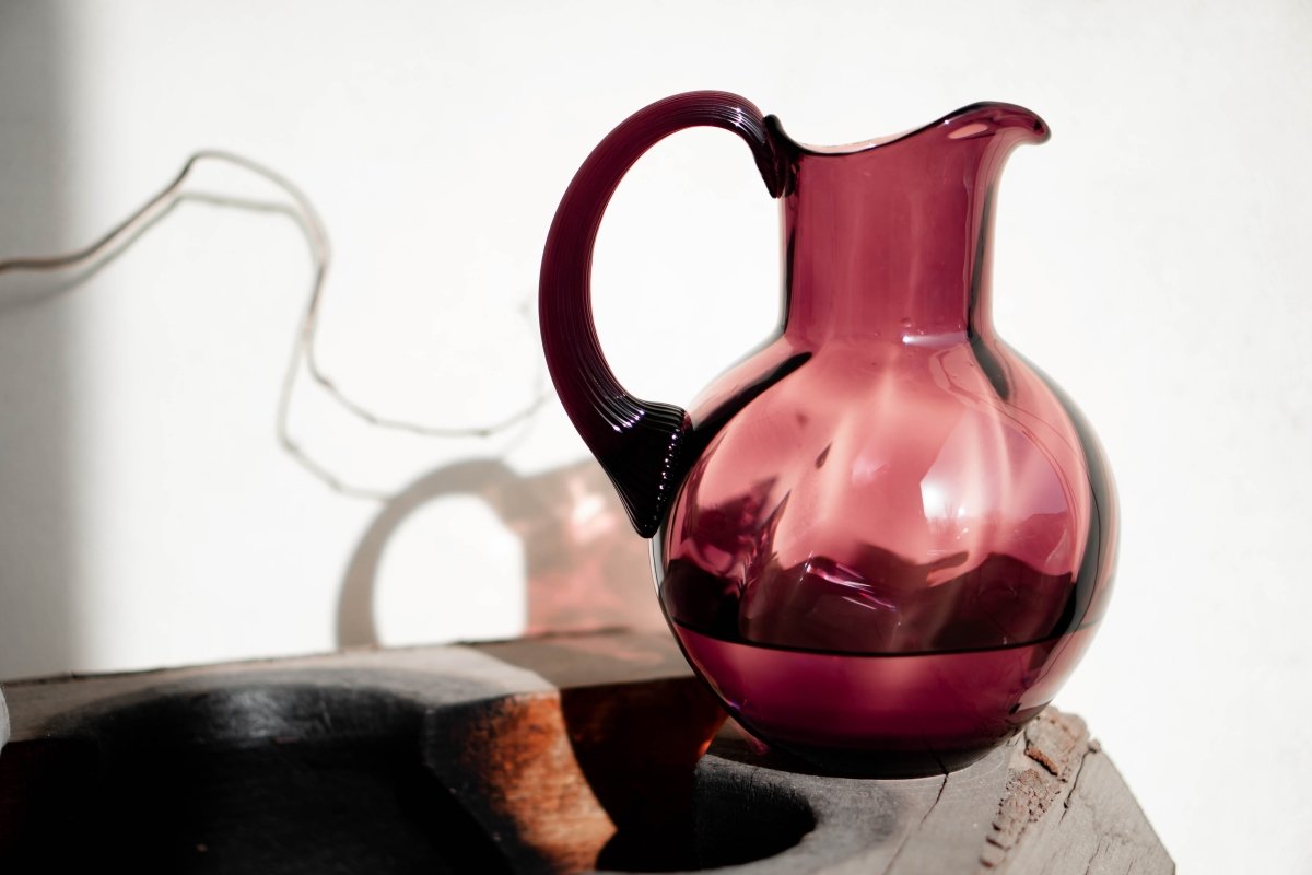 Violet Marika Jug on a wooden glass mould with a white background and shadows