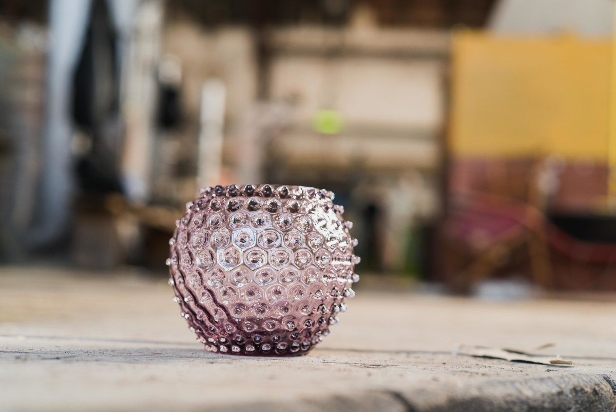 Underlay Violet Hobnail Vase on a cloth-covered wooden floor, with a blurred background