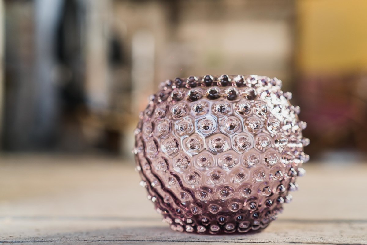 Underlay Violet Hobnail Vase on a cloth-covered wooden floor, with a blurred background